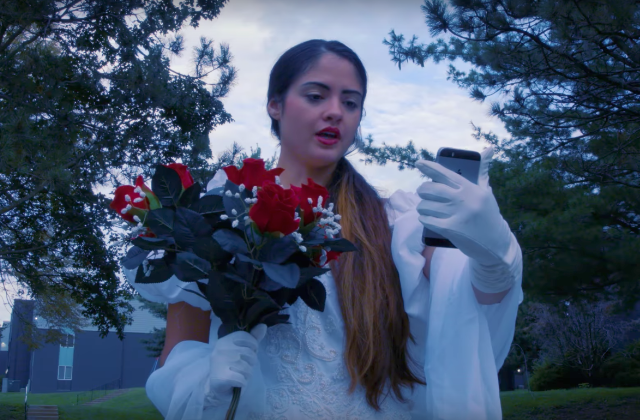 A scene from Citizen's video for their new single "In the Middle of It All" that shows a woman dressed in a wedding dress speaking to her phone.