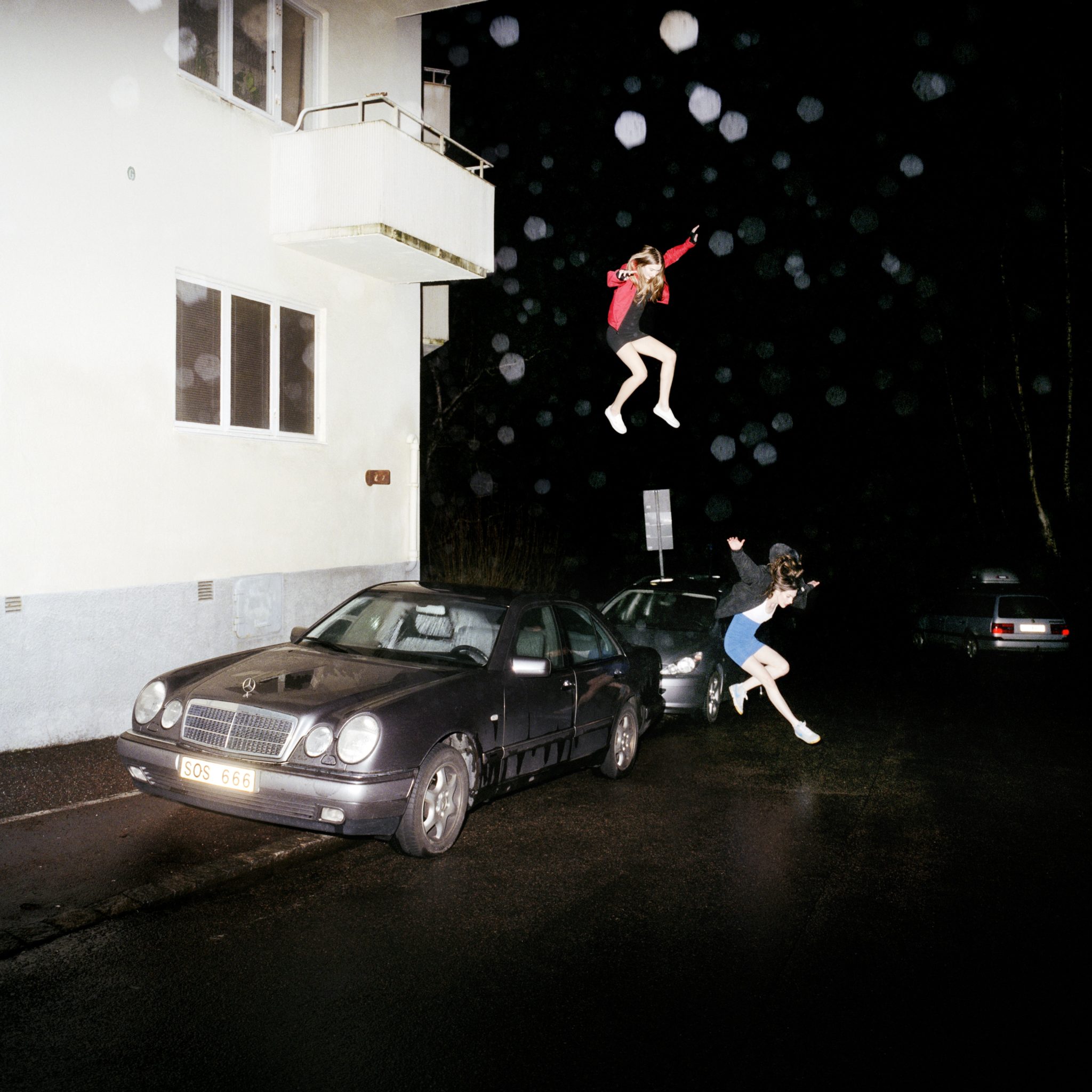 Brand New's "Science Fiction" album art depicts two young women leap gracefully from a window into the street